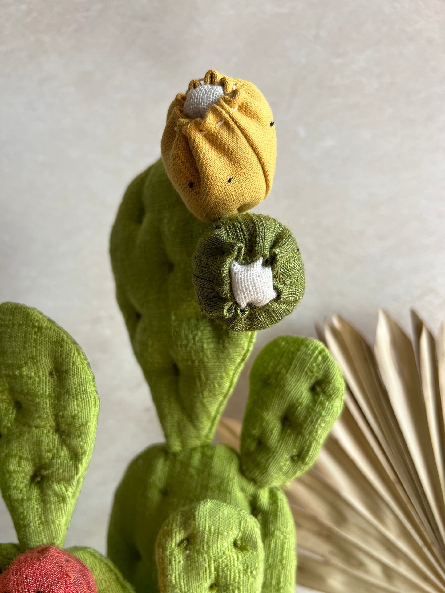 Opuntia in wool fabric complete with white ceramic vase and decorative stones.