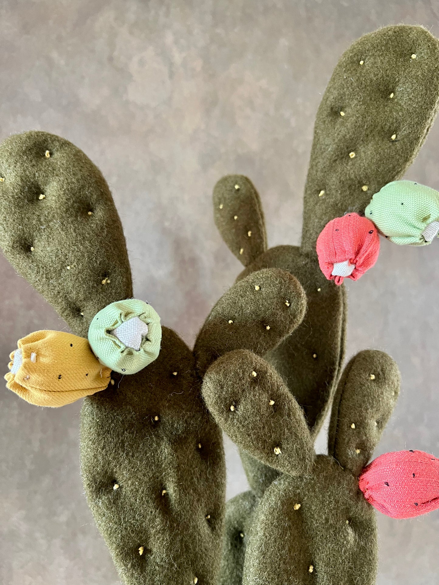 Opuntia in wool fabric complete with white ceramic vase and decorative stones.