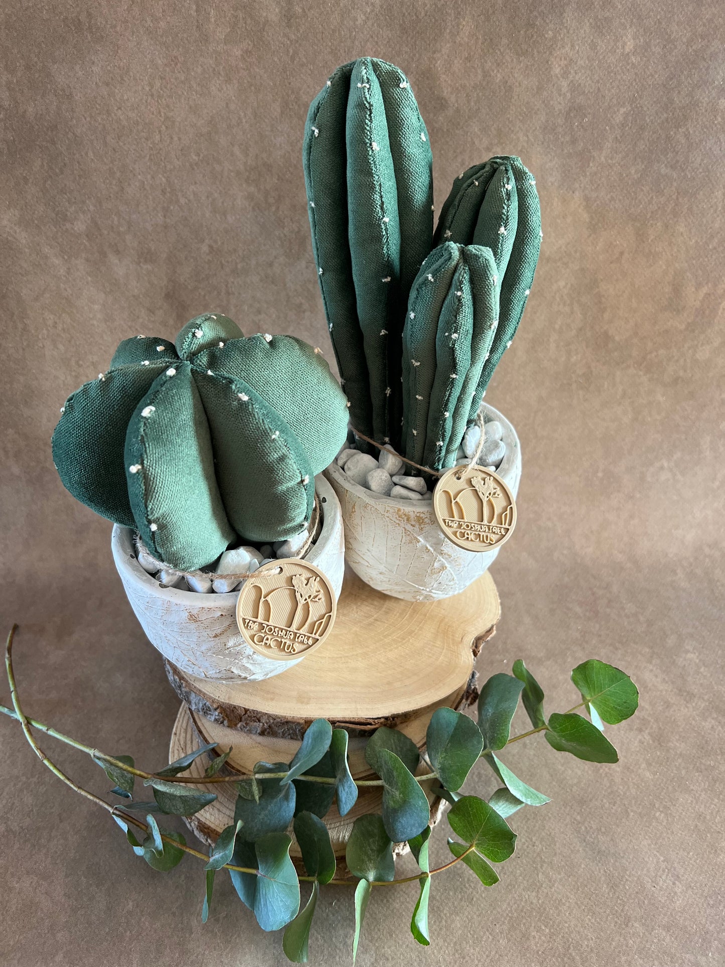 Coppia di composizioni ricamate in vellutino verde, vaso in cemento con motivi a foglia, h circa 19 e 27 cm