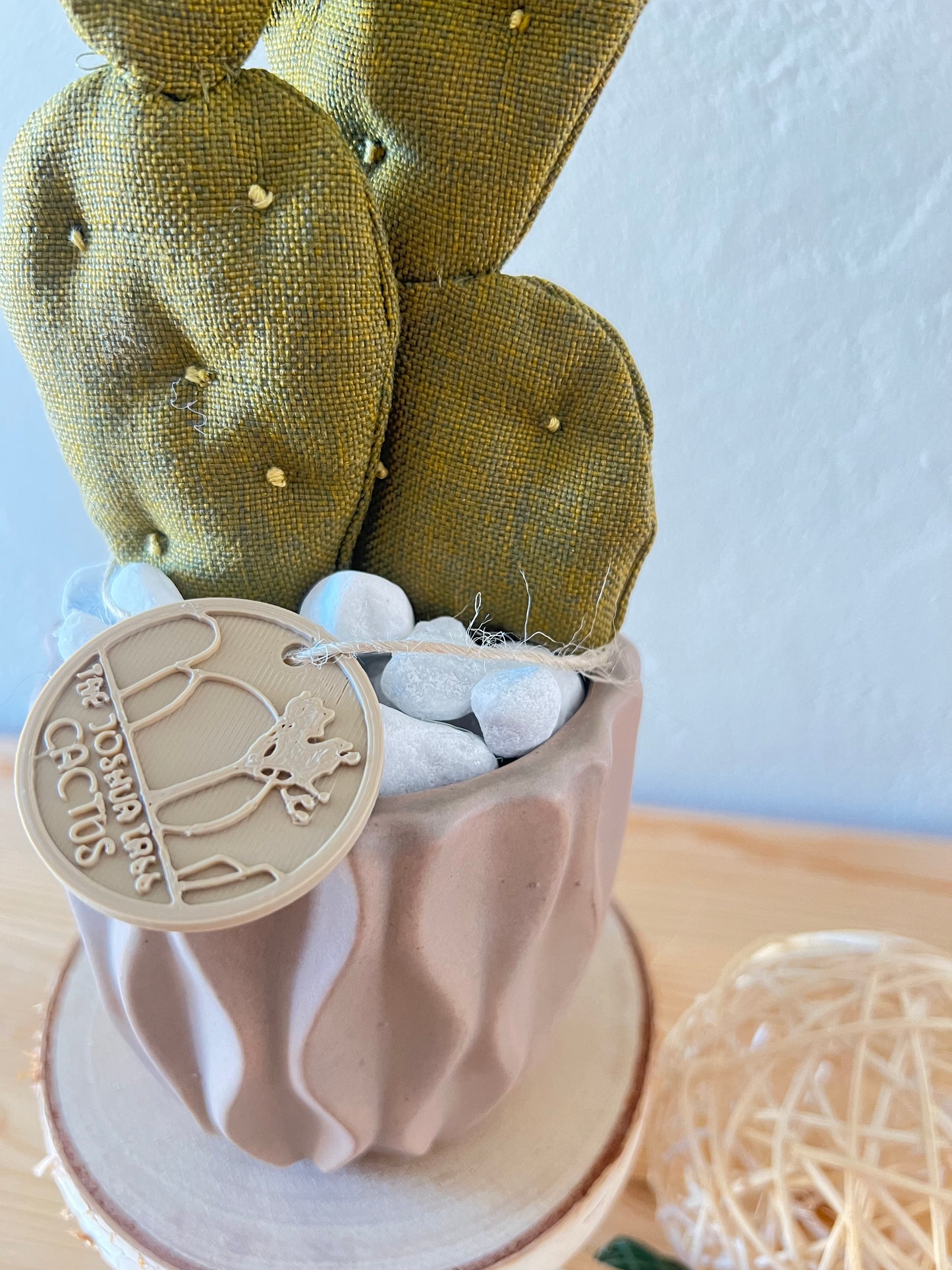 Opuntia in wool fabric complete with white ceramic vase and decorative stones.
