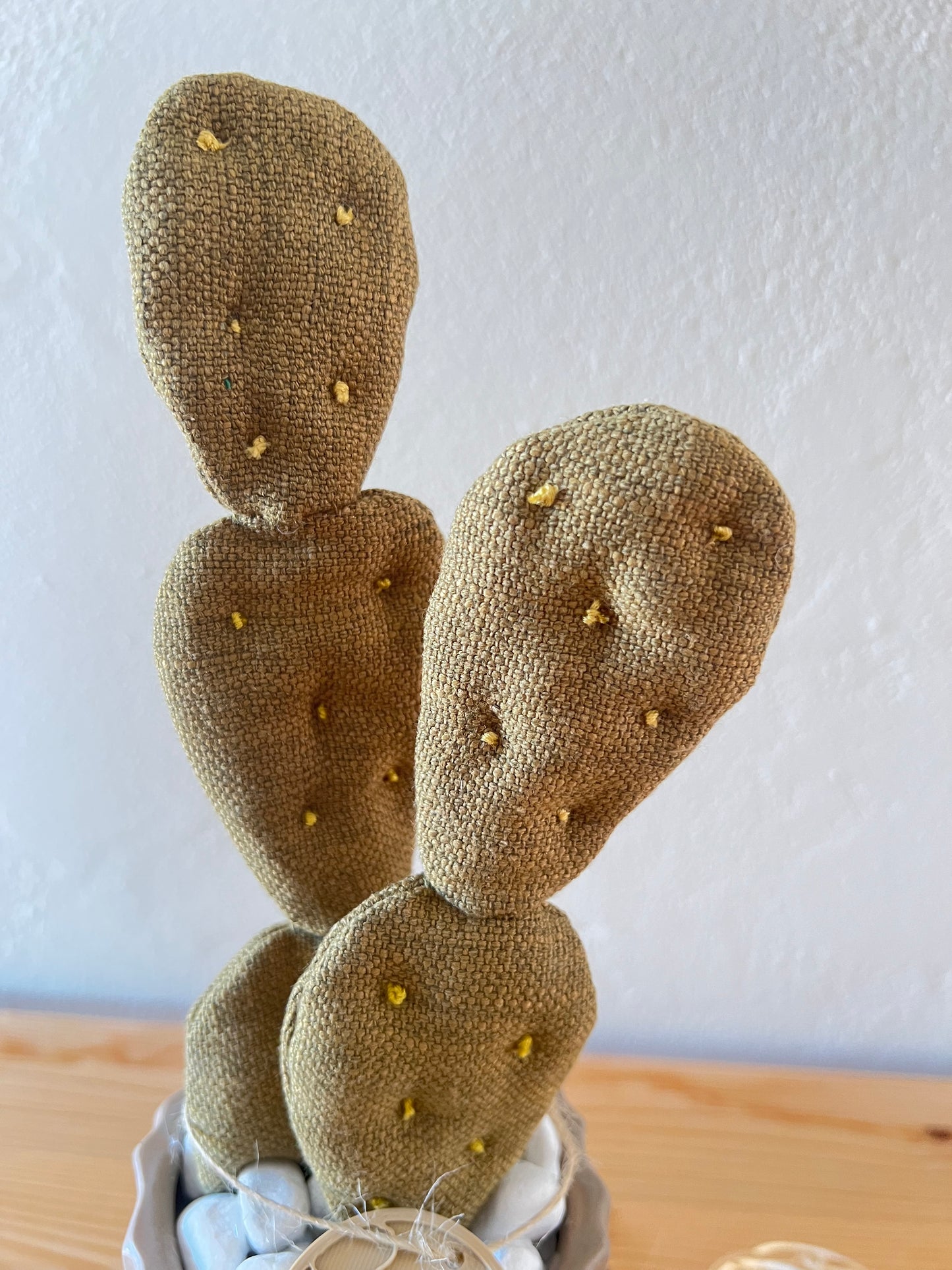 Opuntia in wool fabric complete with white ceramic vase and decorative stones.
